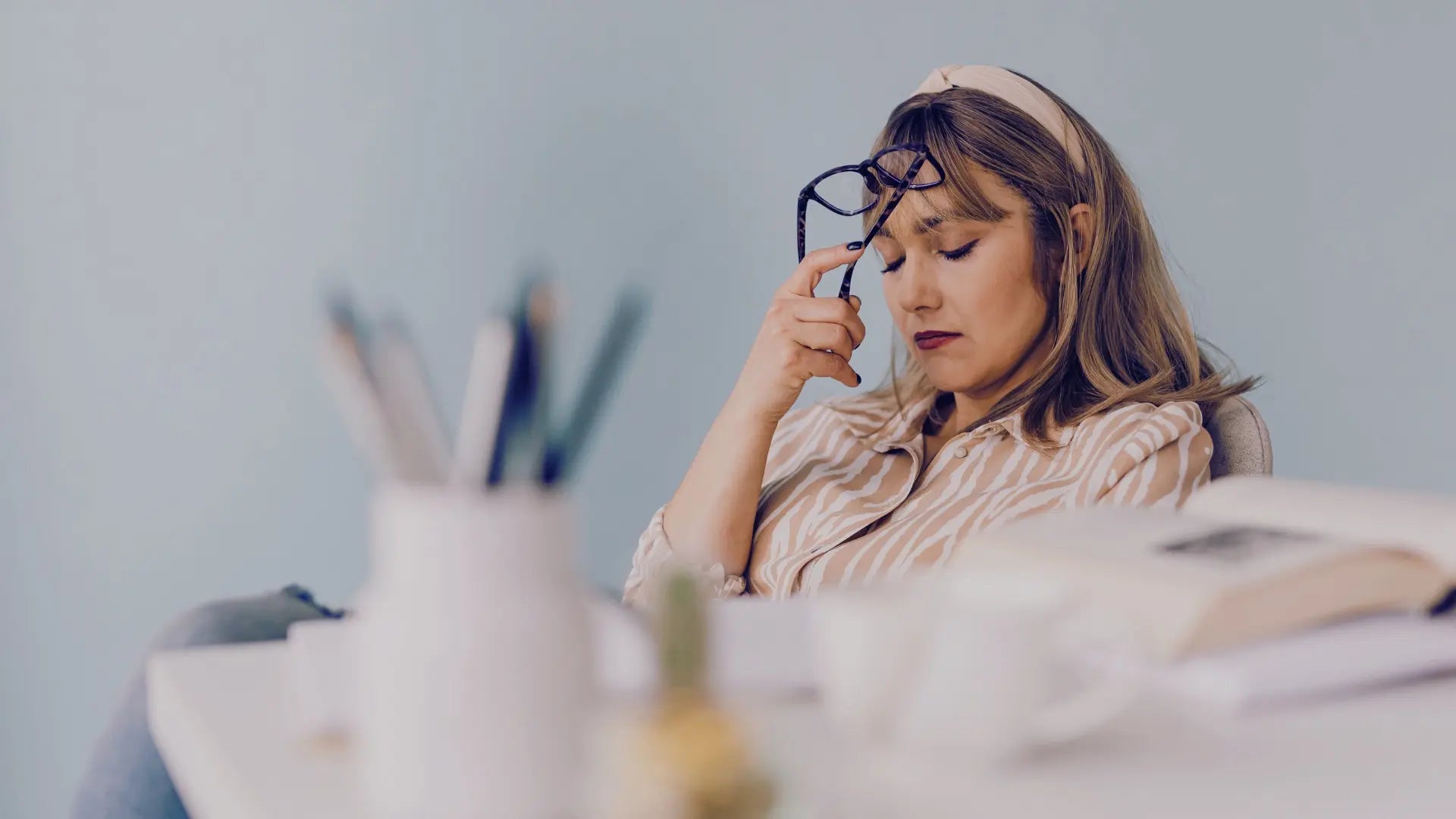 Femme fatiguée devant son bureau symbolisant le besoin de revitalisation naturelle et d'antioxydants puissants issus des baies de goji pour retrouver de l'énergie. Image