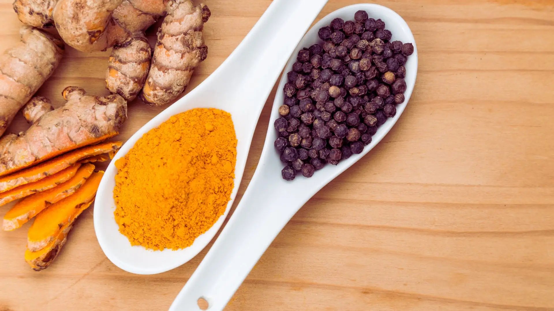 Racines de curcuma et grains de poivre noir dans des cuillères, illustrant la synergie des principes actifs pour une efficacité maximale Image